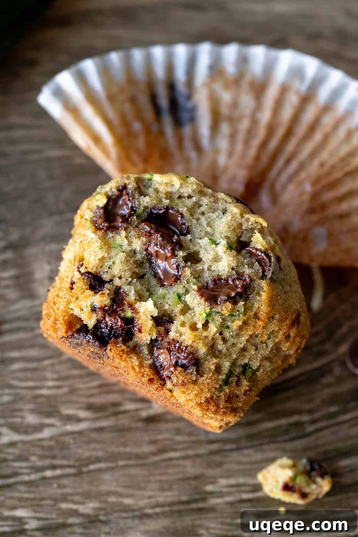 Secret Zucchini Chocolate Chip Muffins 7 A freshly baked zucchini chocolate chip muffin broken in half, revealing its moist interior and melted chocolate