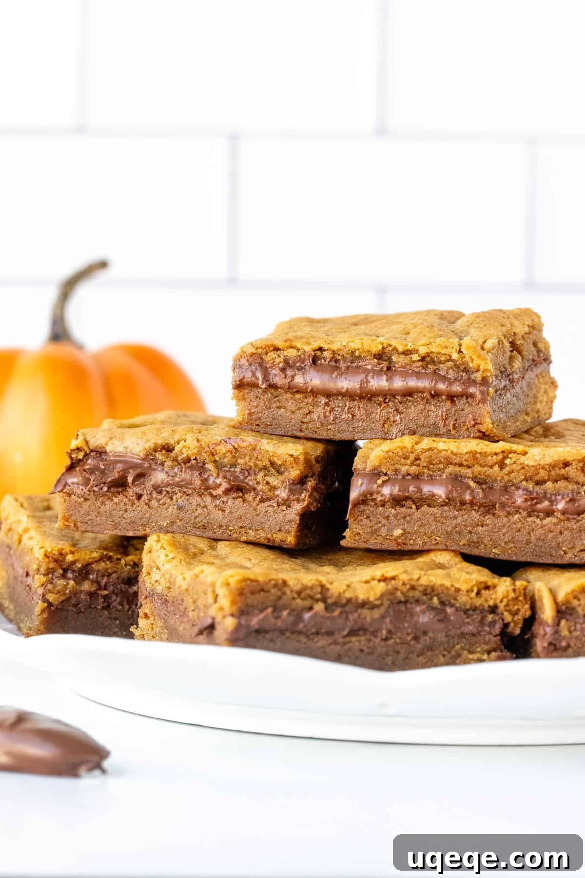 Pumpkin Blondies with a Nutella Heart 3 A plate of perfectly stacked Nutella stuffed pumpkin blondies, ready to be enjoyed.
