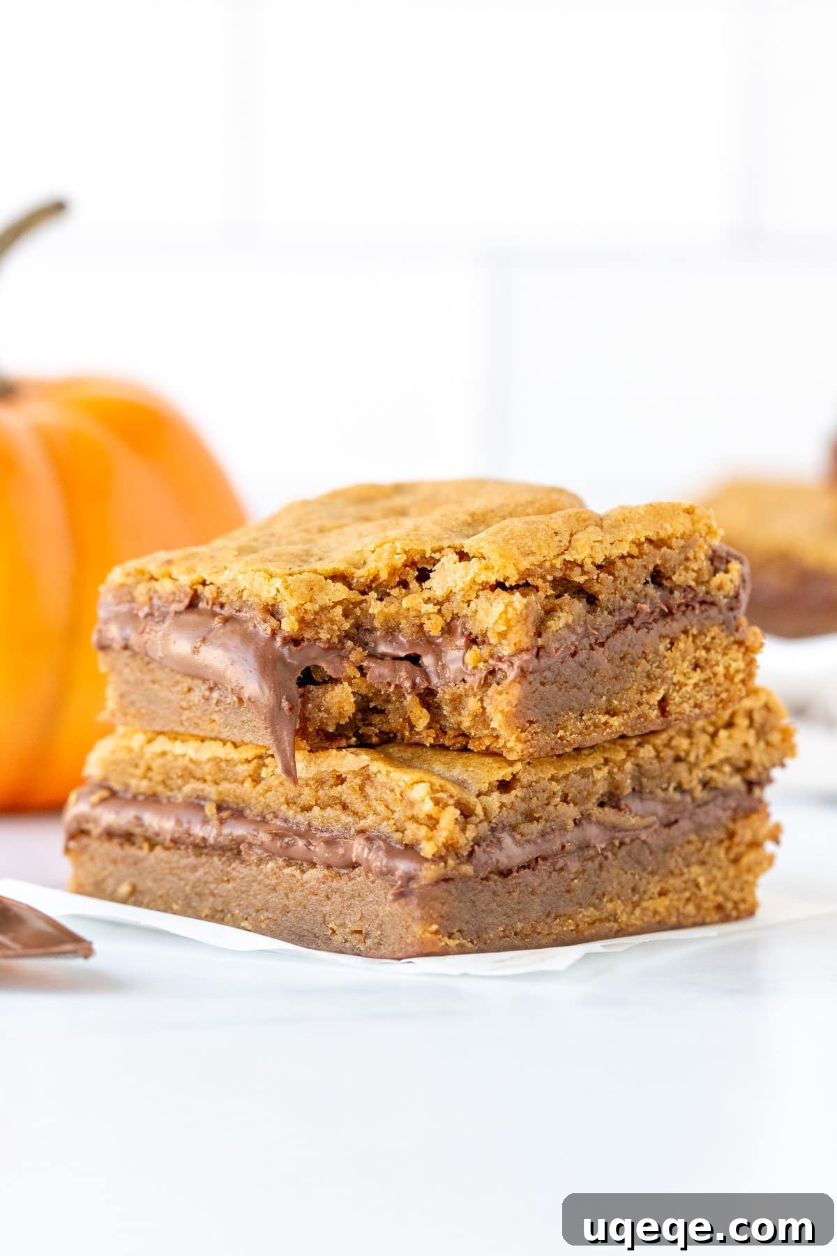 Pumpkin Blondies with a Nutella Heart 10 Stack of two Nutella pumpkin blondies, with a delicious bite taken out of the top one, revealing the luscious Nutella core.