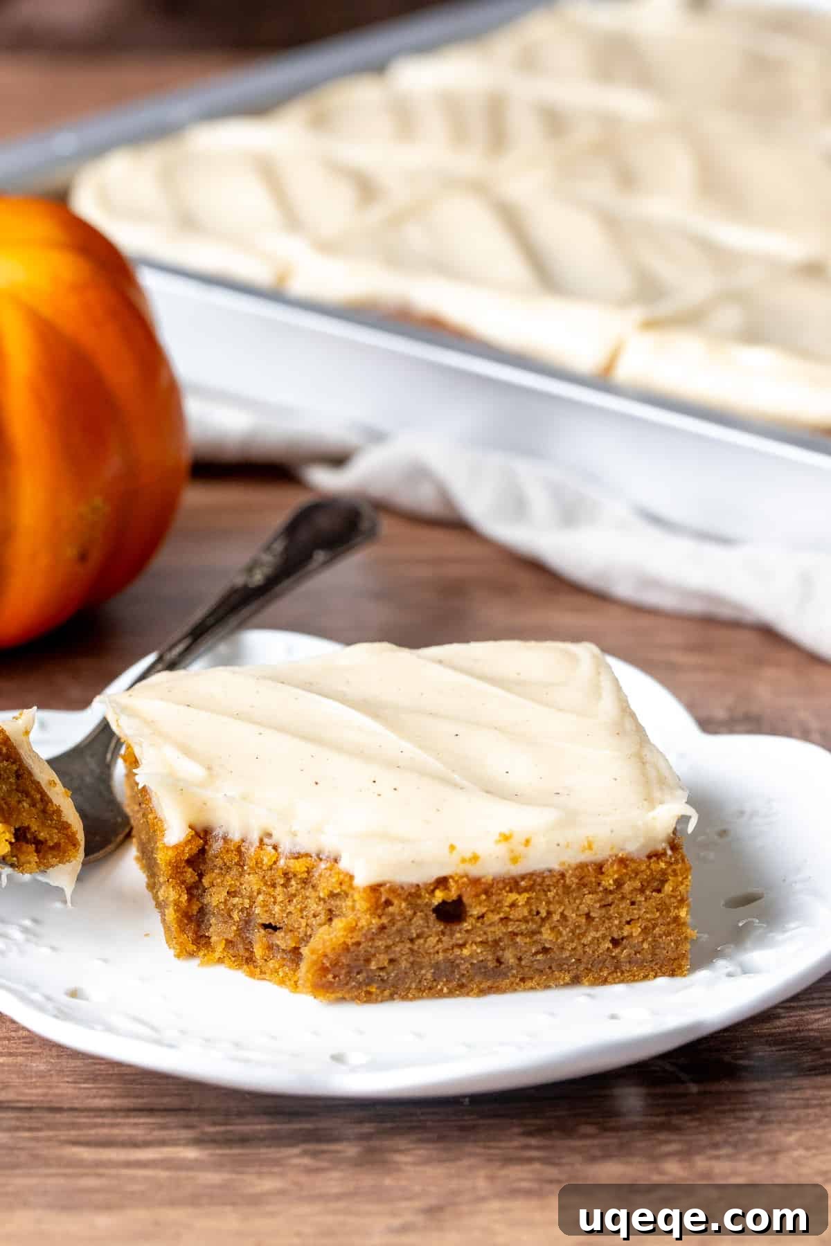 Rich Pumpkin Bars with Spiced Cream Cheese Frosting 7 A perfectly frosted pumpkin bar with a bite taken out, revealing its moist, tender interior and the thick, creamy cinnamon cream cheese frosting on top.