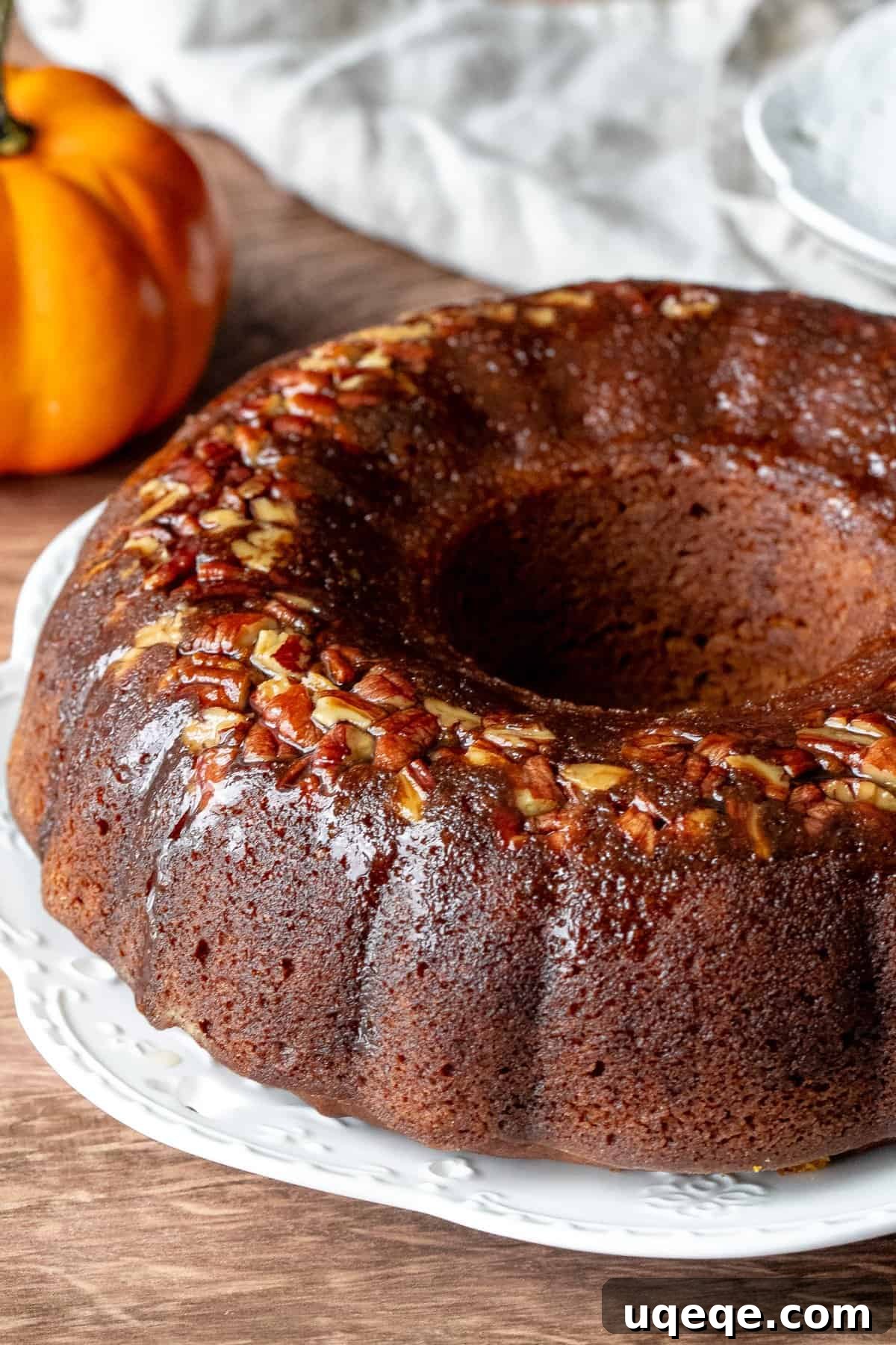 Golden Pumpkin Rum Spice Cake 2 Delicious Pumpkin Rum Cake made in a bundt pan, garnished and ready to serve on a white plate. Perfect for fall celebrations.