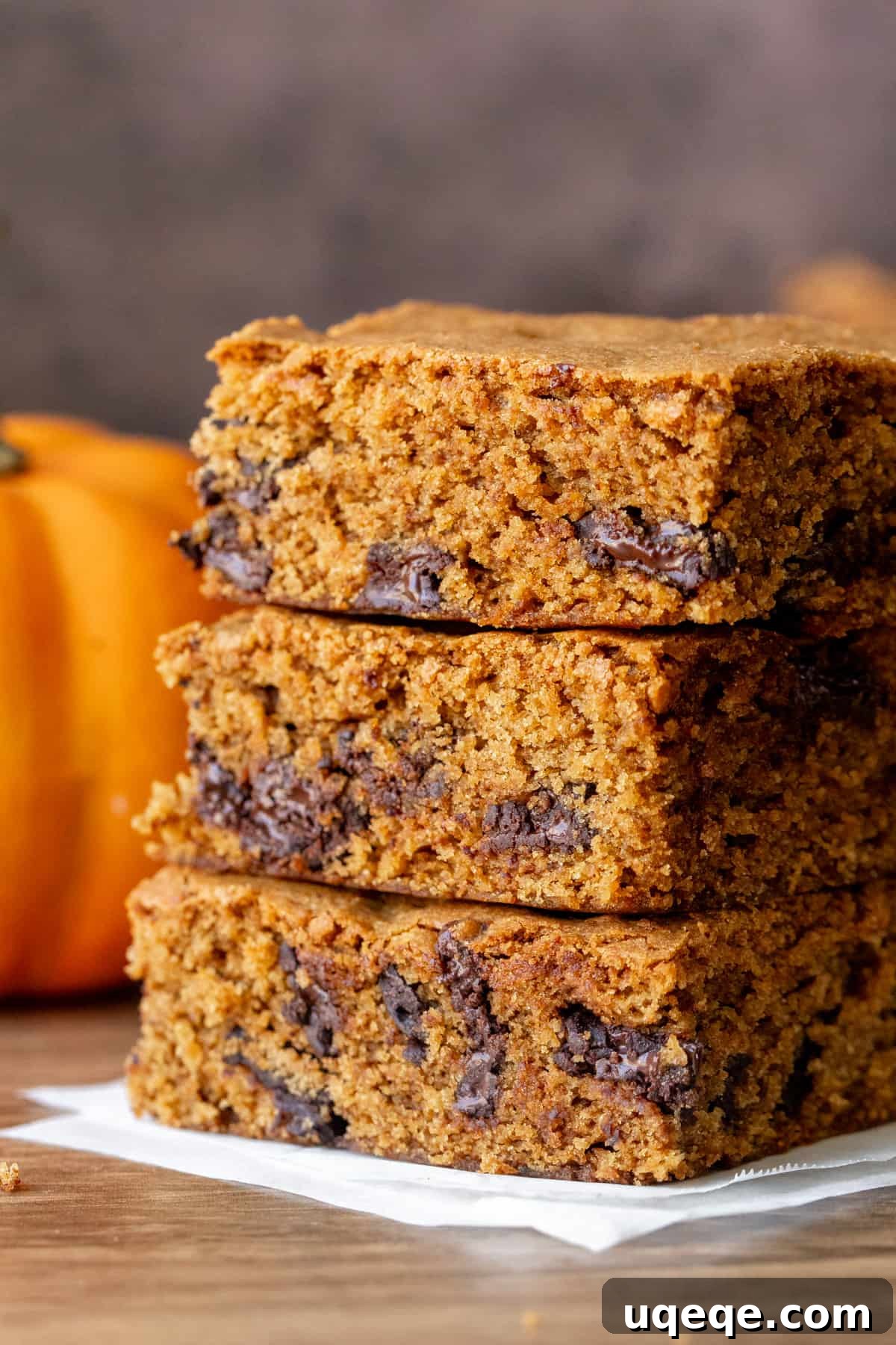 Harvest Pumpkin Chocolate Chip Delights 2 Stack of three moist pumpkin chocolate chip bars, highlighting their chewy texture and abundance of chocolate chips.