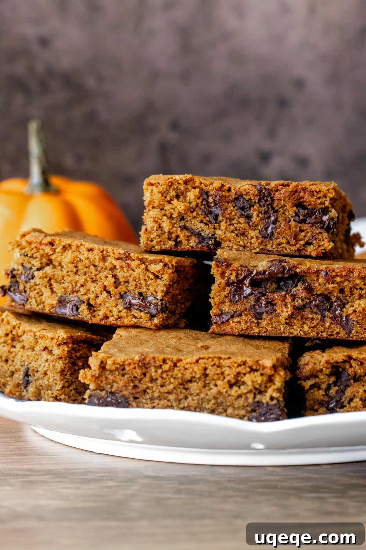 Harvest Pumpkin Chocolate Chip Delights 3 Plate of pumpkin chocolate chip bars, showcasing their golden brown tops and rich chocolate inside.