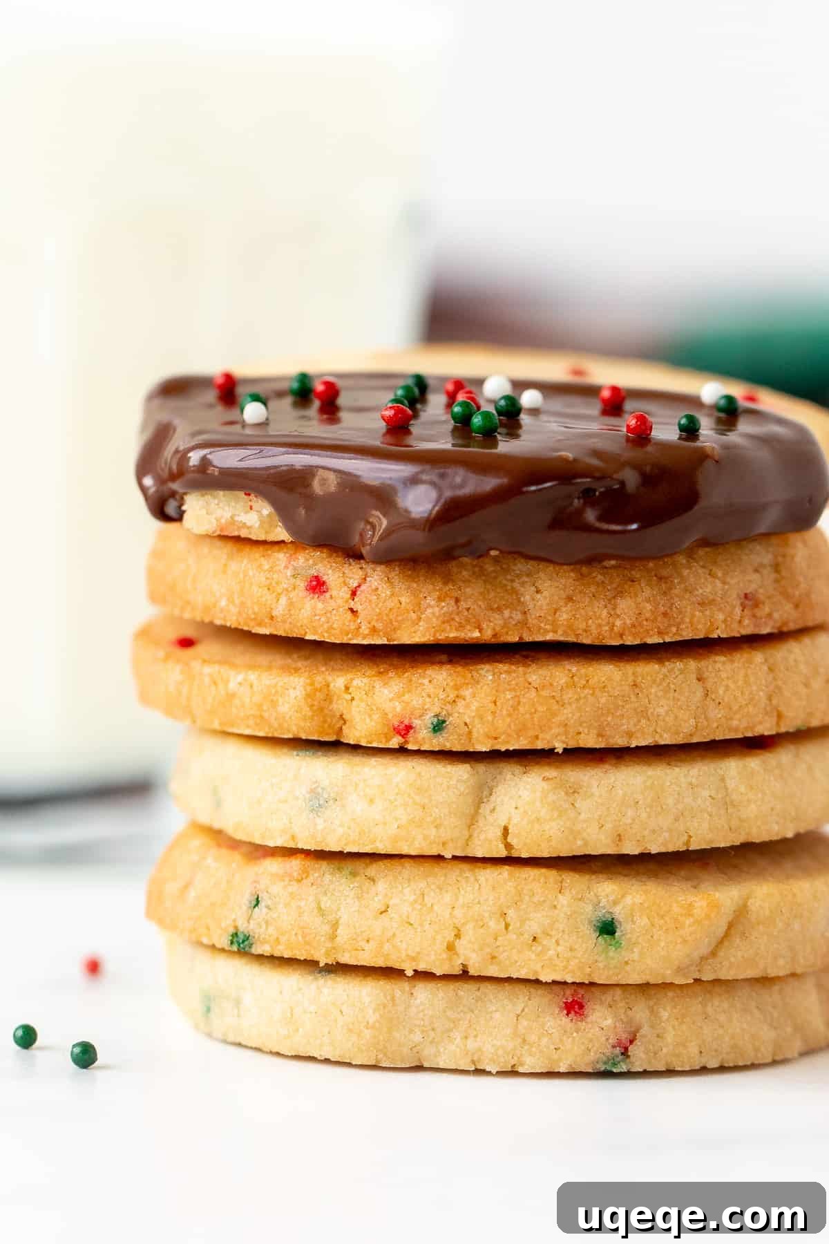 Holiday Sparkle Slice and Bake Cookies 2 Stack of festive Christmas sprinkle slice and bake cookies, one dipped in chocolate with extra sprinkles