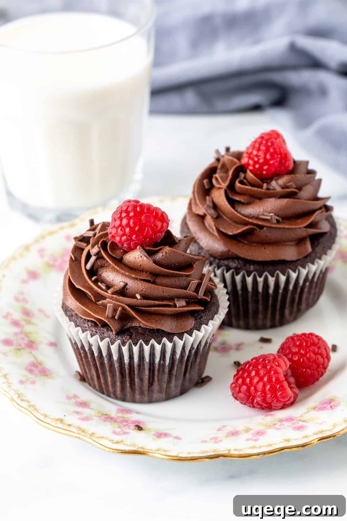 Perfect Pair Chocolate Cupcakes 2 Two rich chocolate cupcakes, perfectly frosted and ready to be enjoyed, served alongside a refreshing glass of milk.