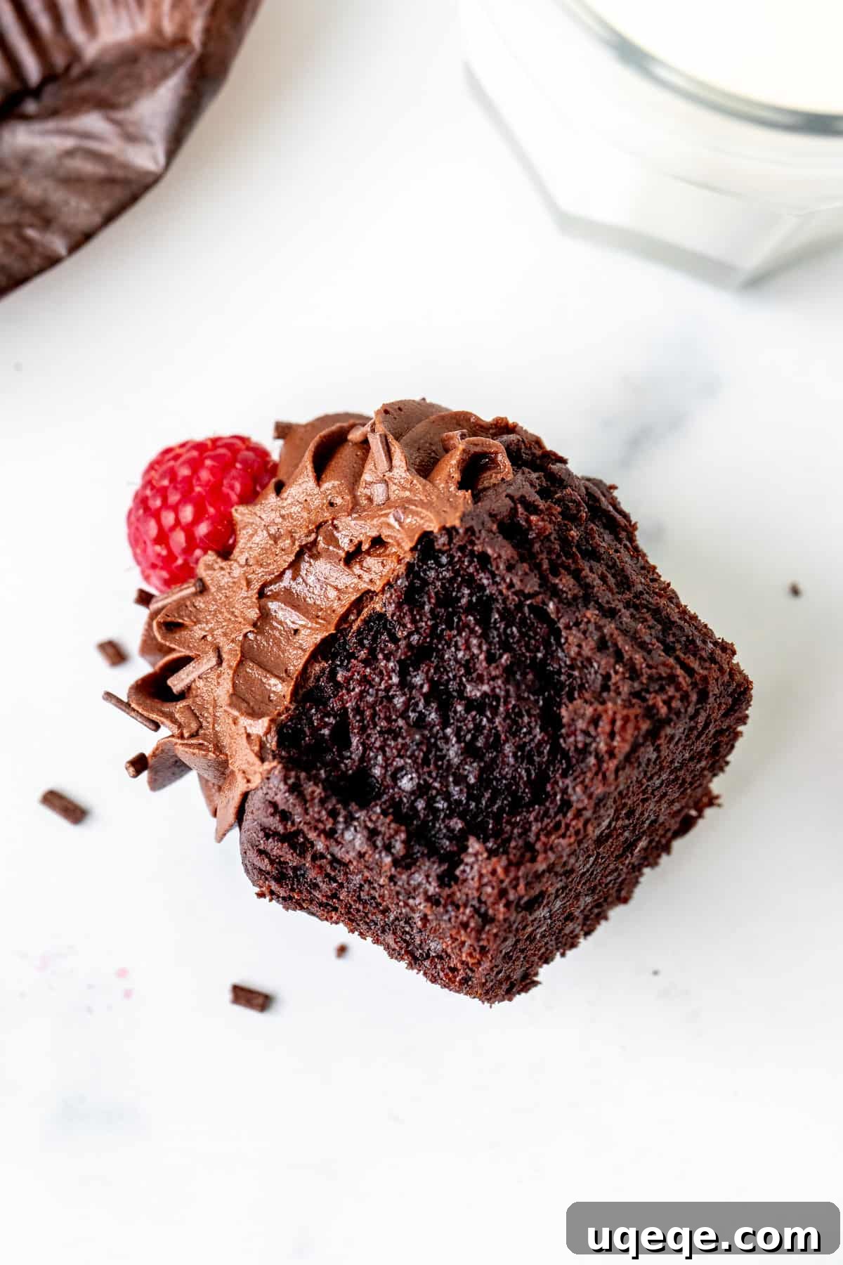 Perfect Pair Chocolate Cupcakes 6 A delectable chocolate cupcake, turned on its side, revealing a perfect bite taken out of its moist and fudgy interior.