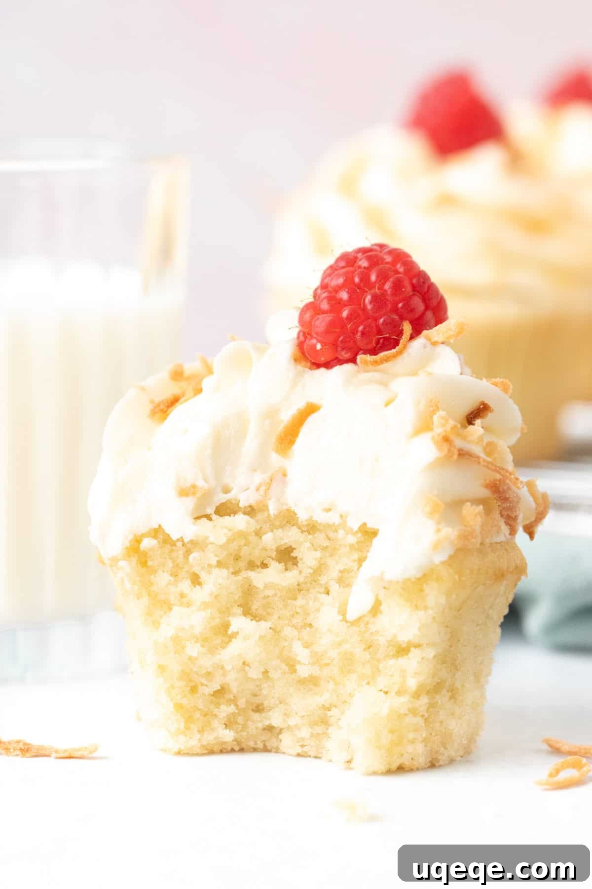Tropical Cloud Cupcakes 5 Coconut cupcake with a bite taken out, with glass of milk