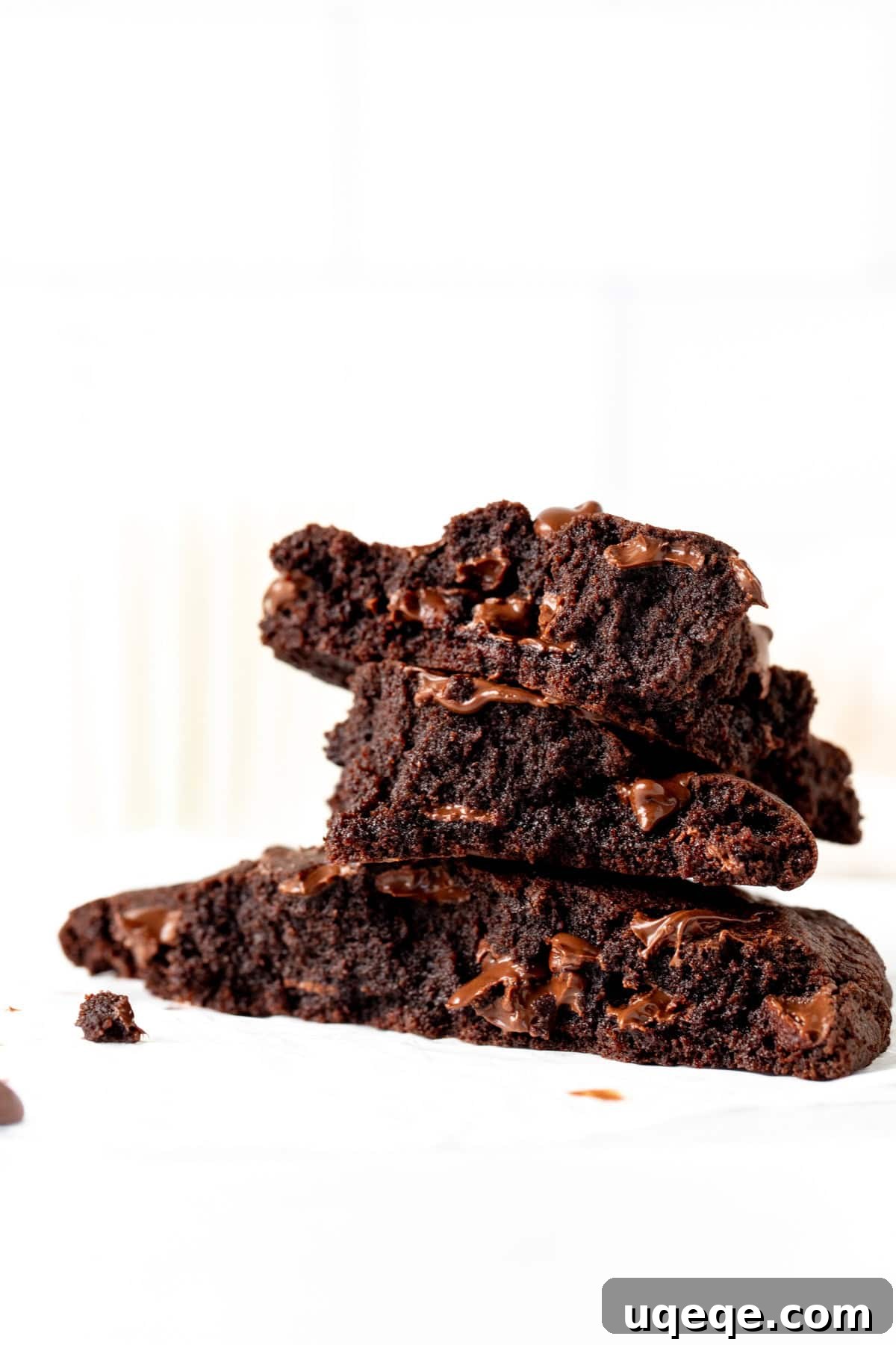 Solo Chocolate Delight 8 Single serving double chocolate cookie broken into pieces, with pieces stacked on top of each other, showcasing its gooey texture and inviting a bite.