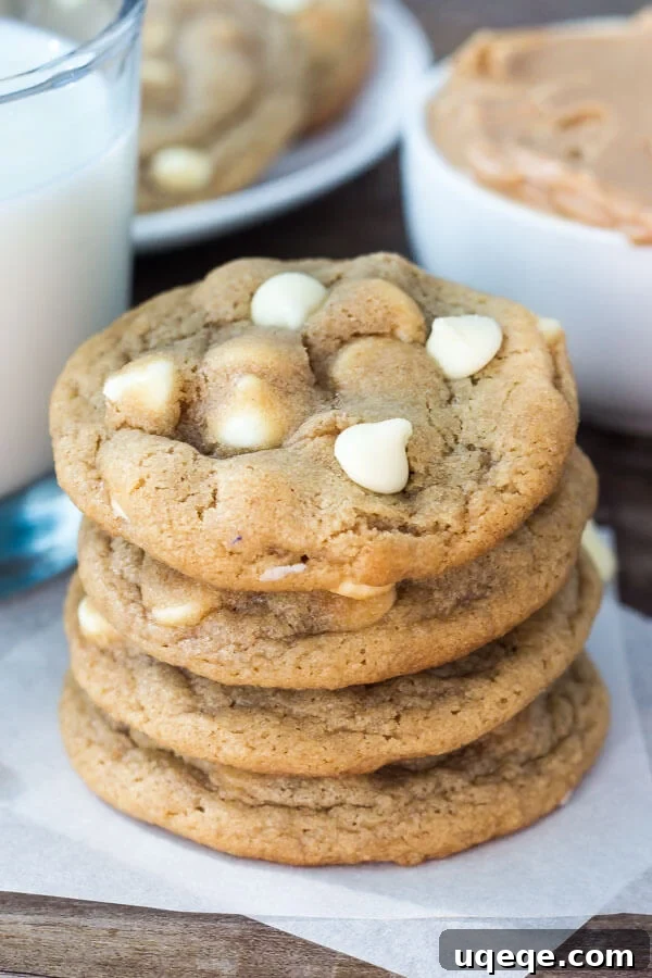Peanut Butter White Chocolate Chip Delights 5 Stack of peanut butter white chocolate chip cookies. Glass of milk and second plate of cookies in the background.