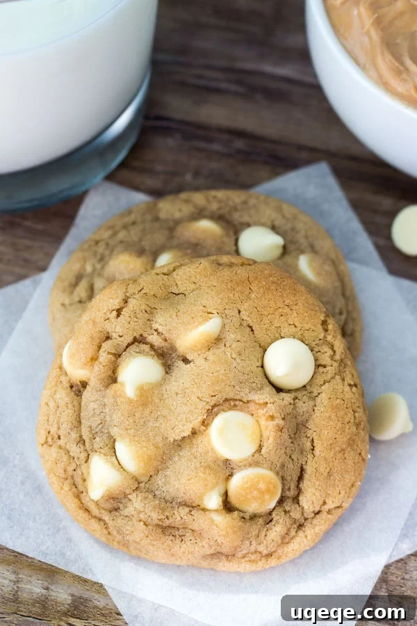 Peanut Butter White Chocolate Chip Delights 6 Two peanut butter white chocolate chip cookies on white napkin with white chocolate chips scattered around.