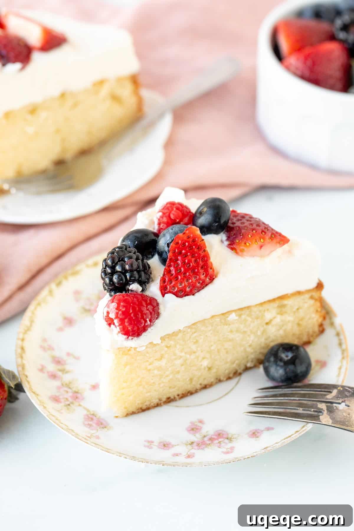 Velvet Berry Bliss Cake 3 A perfectly sliced piece of Berries and Cream Cake, showcasing the moist vanilla cake layer, thick whipped cream, and colorful fresh berries on top.