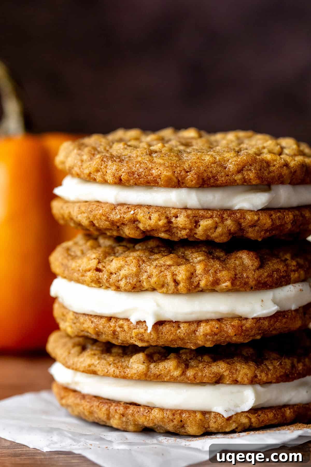 Spiced Pumpkin Oat Creamwiches 2 Three pumpkin oatmeal cream pie cookies, stacked on top of each other, showcasing their delightful layers.