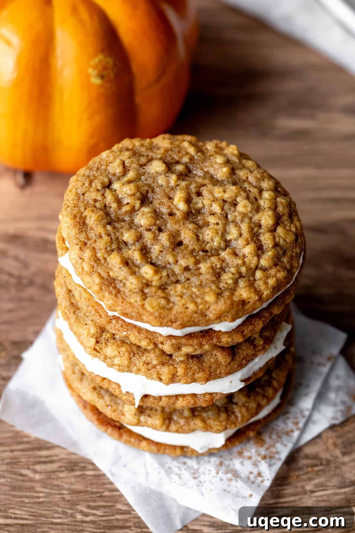 Spiced Pumpkin Oat Creamwiches 3 Stack of three pumpkin cookies sandwiched together with cream cheese frosting, highlighting the creamy filling.
