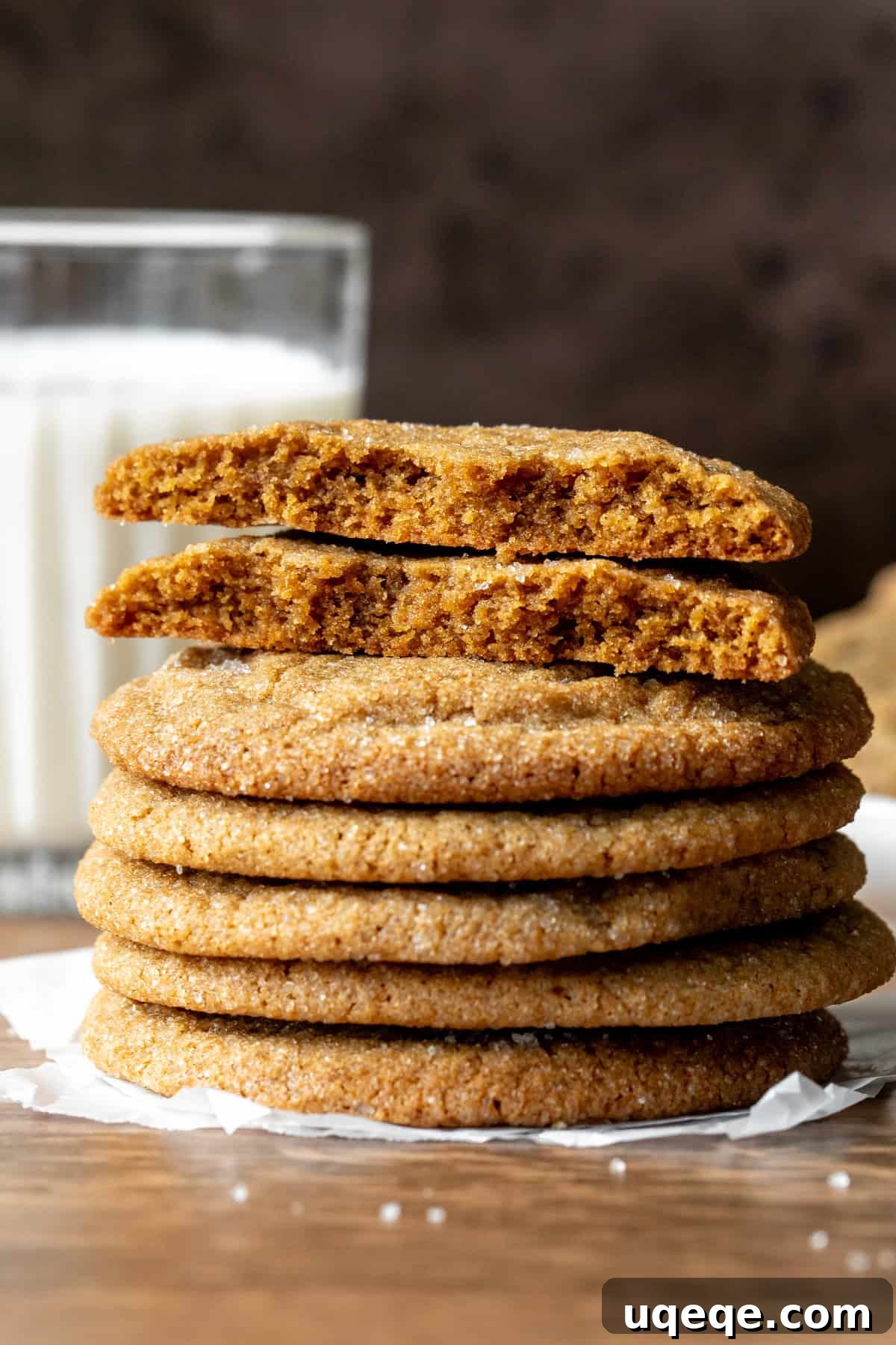 Chewy Brown Sugar Delights 8 A tempting stack of brown sugar cookies, with one broken in half to reveal its soft interior, next to a refreshing glass of milk.