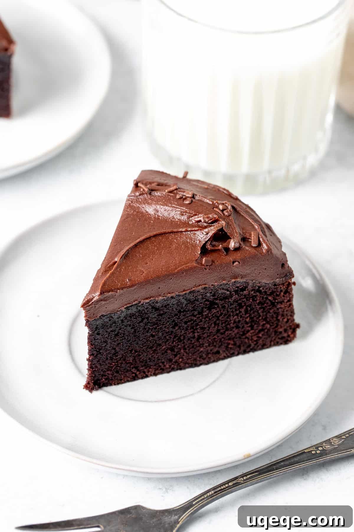 Petite Chocolate Perfection 3 A delectable slice of small chocolate cake with generous chocolate frosting on a plate.