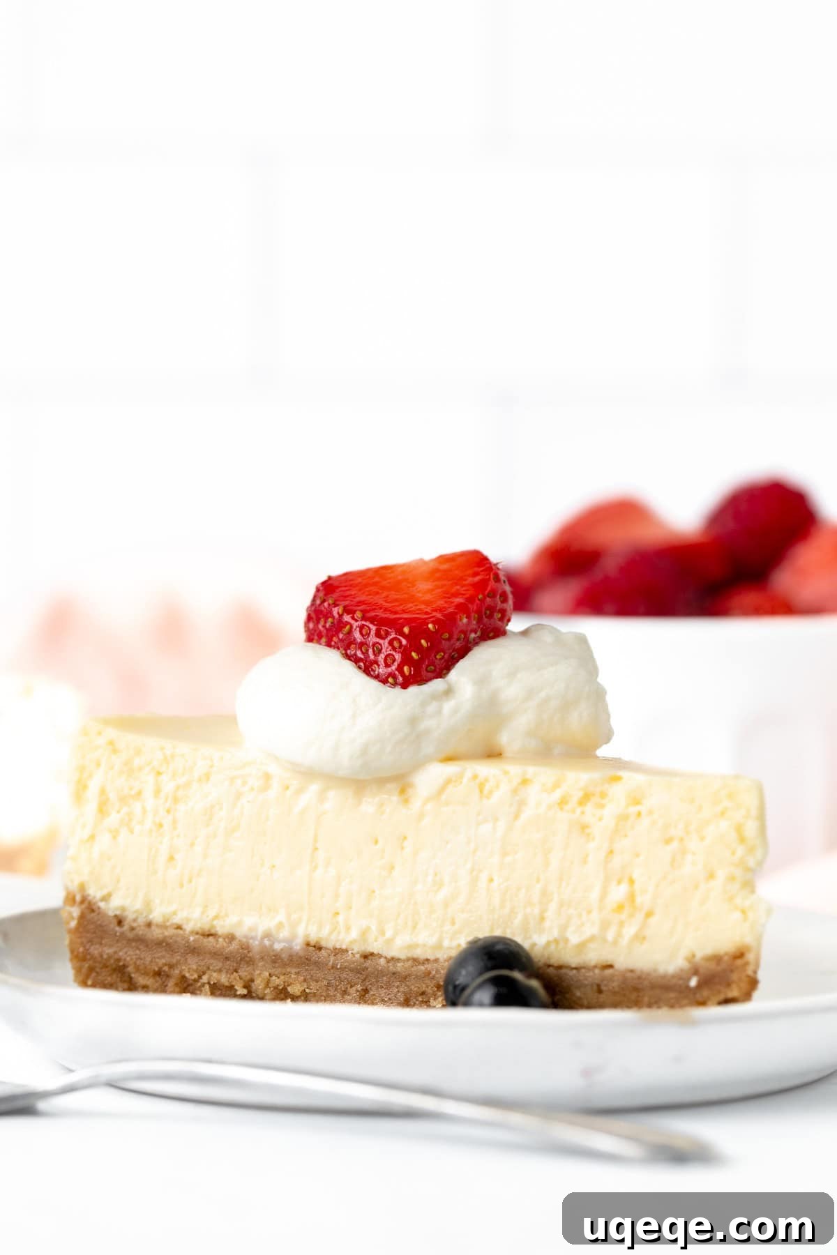 Intimate Batch Cheesecake 2 Small batch cheesecake baked in a loaf pan, garnished with fresh berries and whipped cream.