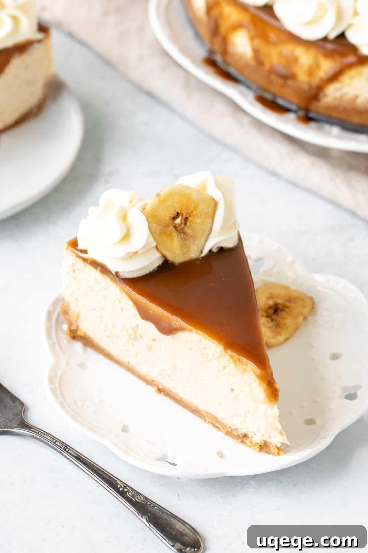 Decadent Banoffee Cheesecake 2 A beautifully presented whole banoffee cheesecake with caramel drizzle and whipped cream rosettes, ready to be sliced.