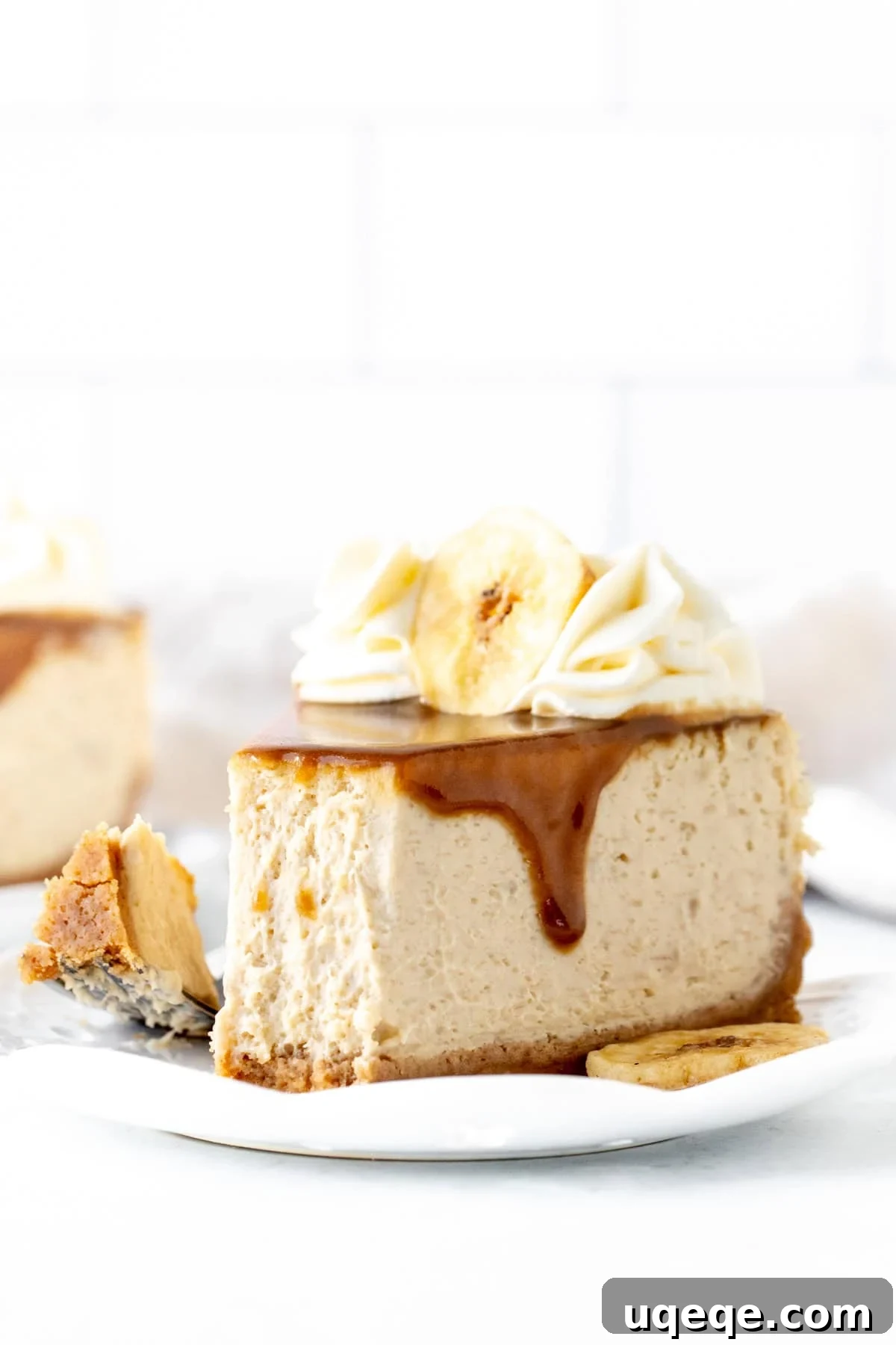 Decadent Banoffee Cheesecake 8 Close-up of the banoffee cheesecake with piped whipped cream rosettes and dried banana slices as garnish.
