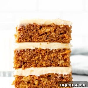 Stack of three homemade carrot cake bars with generous cream cheese frosting