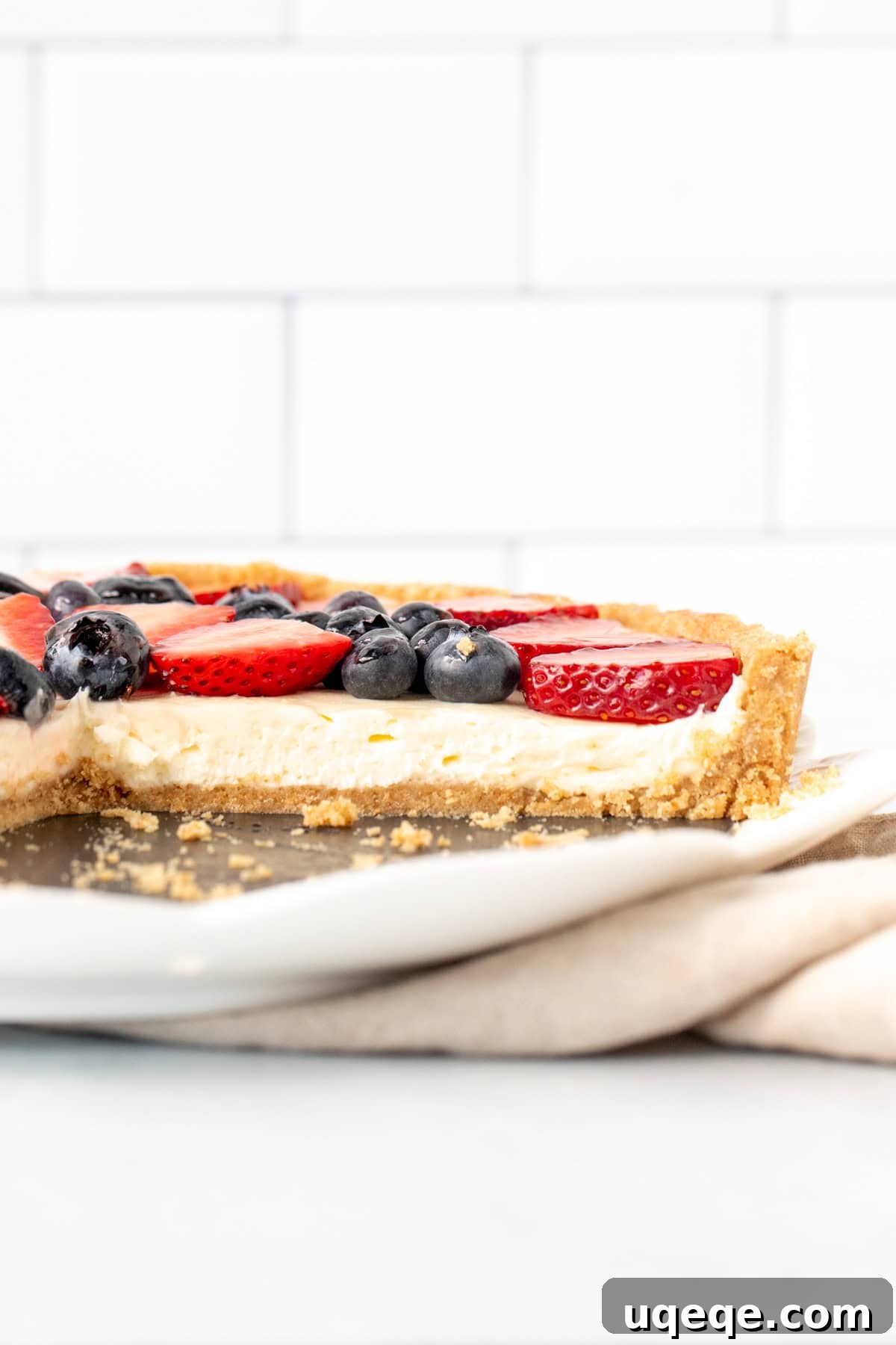 Effortless Rainbow Fruit Delight 9 A simple yet elegant fruit tart featuring a creamy filling and an abundance of fresh fruit atop a graham cracker crust, displayed beautifully on a white plate, showcasing its ready-to-serve charm.