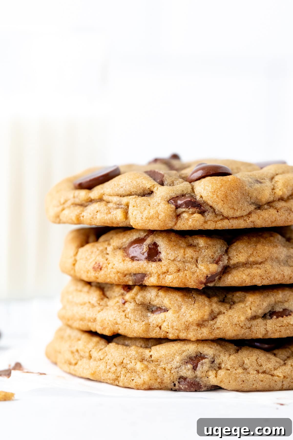 Dreamy Cream Cheese Chocolate Chip Cookies 3 Four thick cream cheese chocolate chip cookies stacked, beside a tall glass of milk.