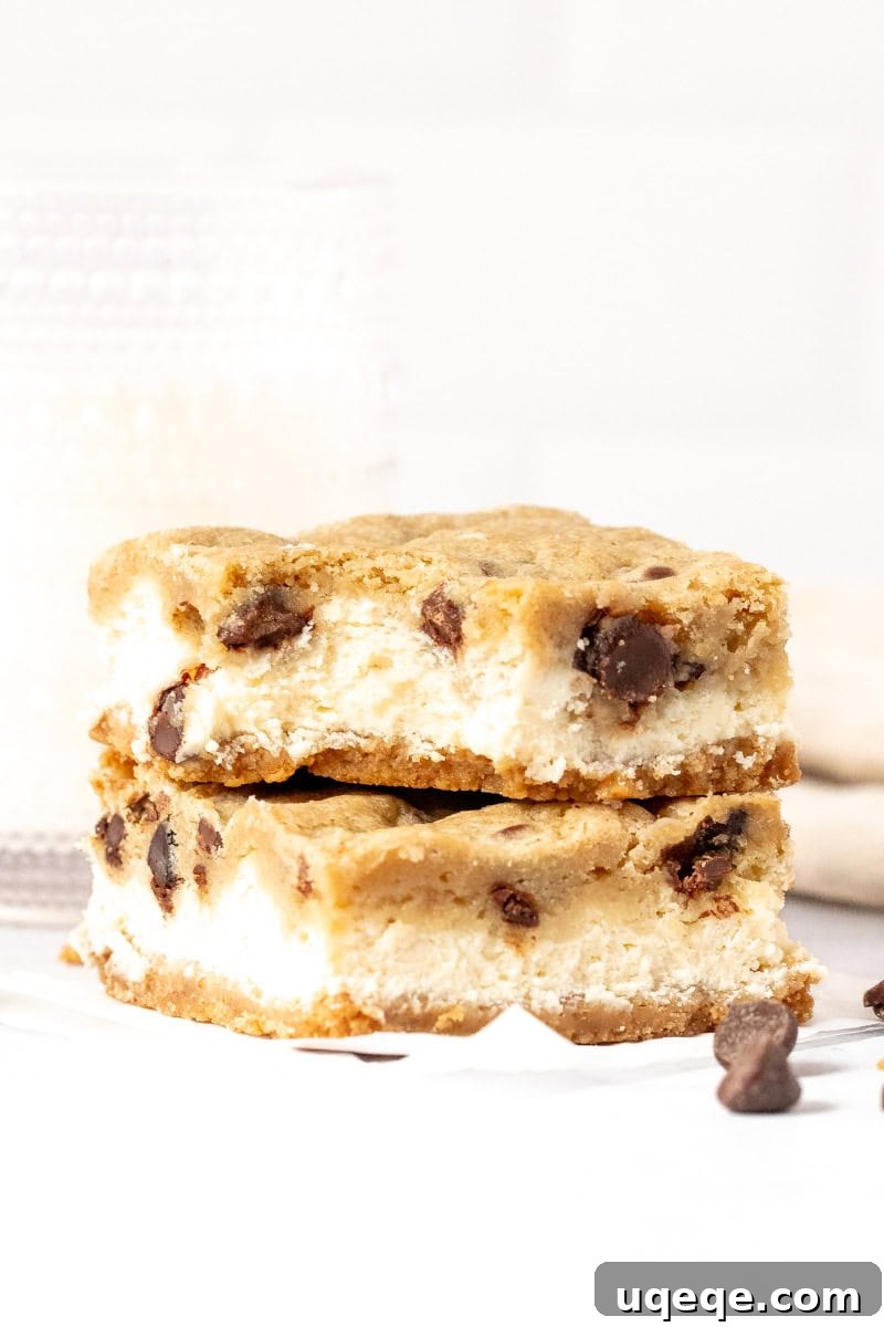 Heavenly Chocolate Chip Cheesecake Bars 12 Two chocolate chip cheesecake bars, with a bite taken out of the top bar, revealing the creamy layers