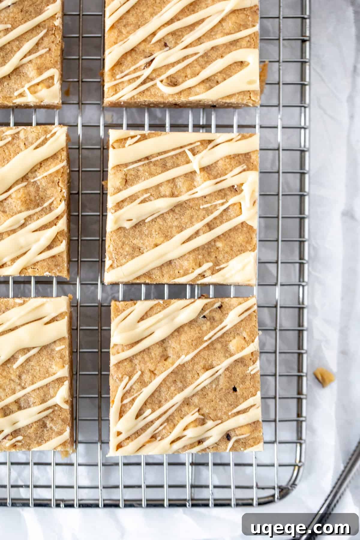 Golden Brown Butter Maple Blondies 6 Maple blondies drizzled with maple glaze, cooling on a rack, showcasing their irresistible appeal.