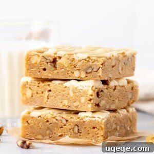 Stack of three maple nut blondies drizzled with maple glaze