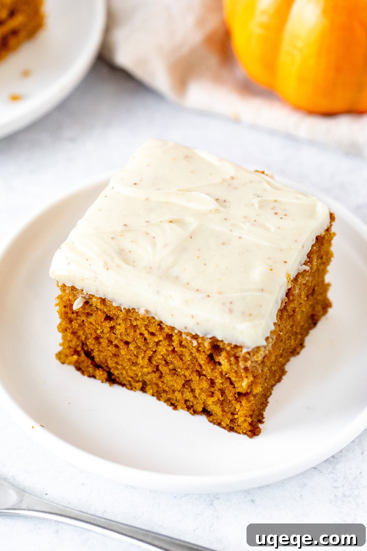 Warm Spiced Pumpkin Delight 4 A generous slice of pumpkin sheet cake with a thick layer of brown butter cream cheese frosting, perfect for fall.