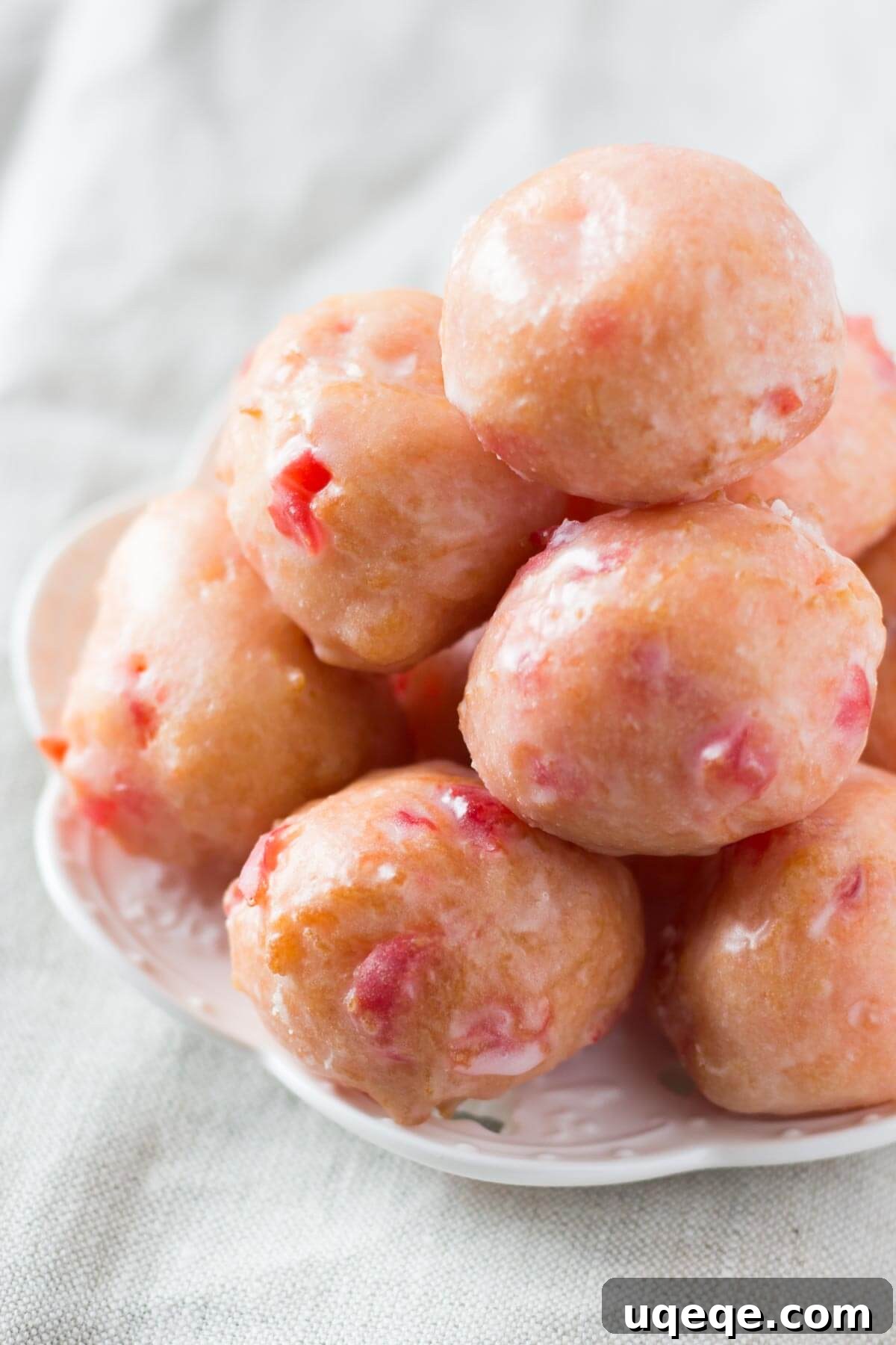 Cherry Doughnut Poppers 2 Delicious homemade Cherry Doughnut Holes, perfectly pink and drizzled with a sweet glaze, ready to be enjoyed.