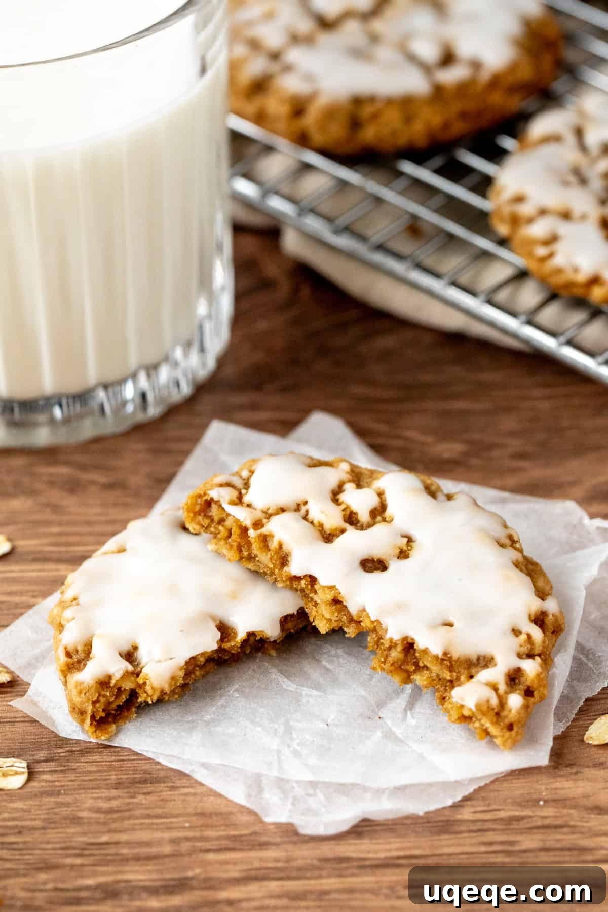 Glazed Oatmeal Delights 2 A perfectly baked iced oatmeal cookie broken in half, showcasing its tender, chewy interior and thick vanilla icing.