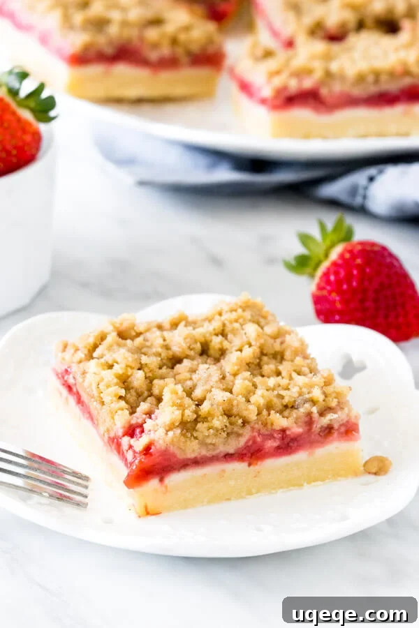 Strawberry bar with crumb topping on a white plate with a fork.