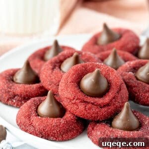 Plate of red velvet blossom cookies, each cookie topped with a Hershey's Kiss