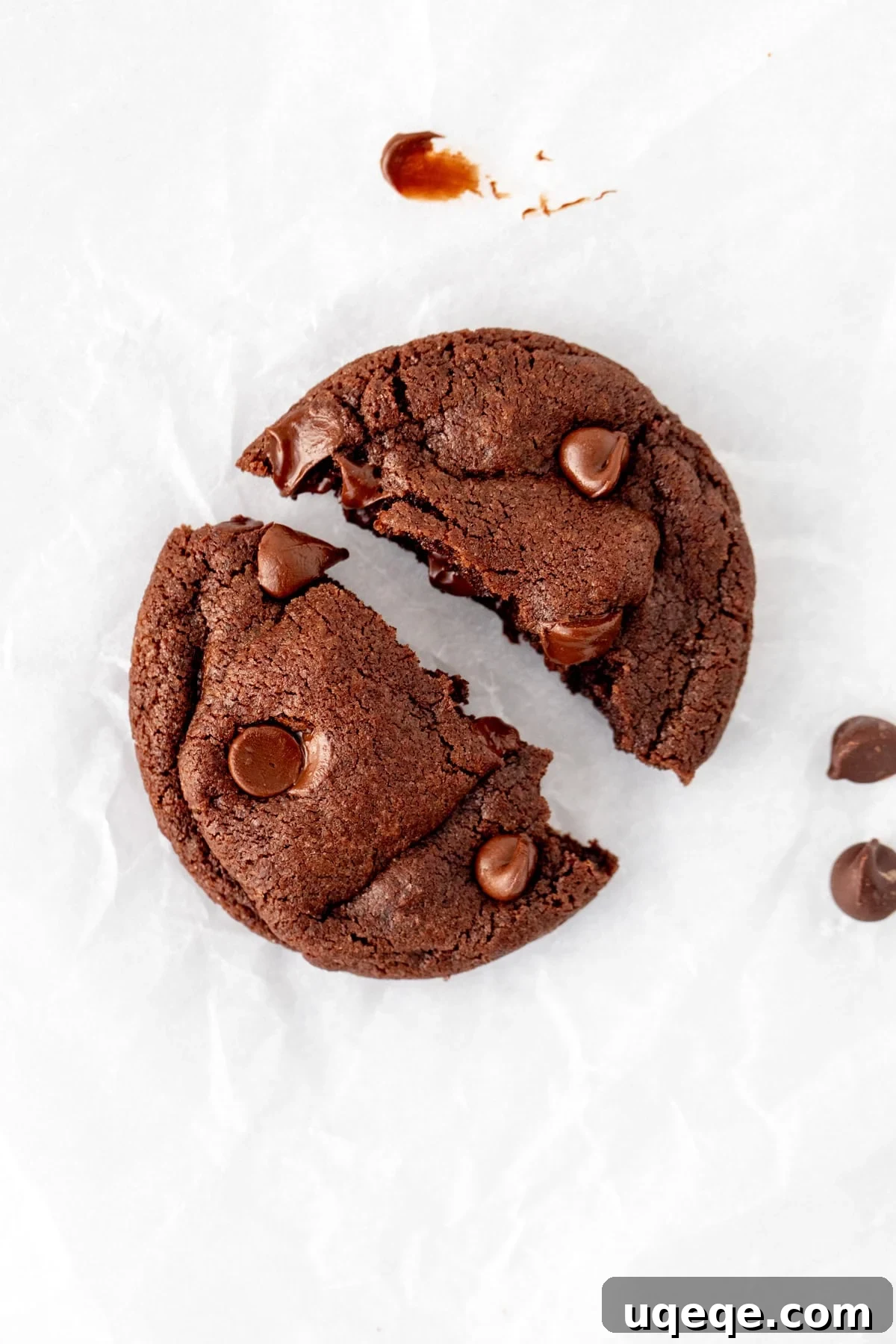 A decadent double chocolate cookie from the small batch recipe, beautifully broken in half to reveal its soft, gooey center and melted chocolate chips.