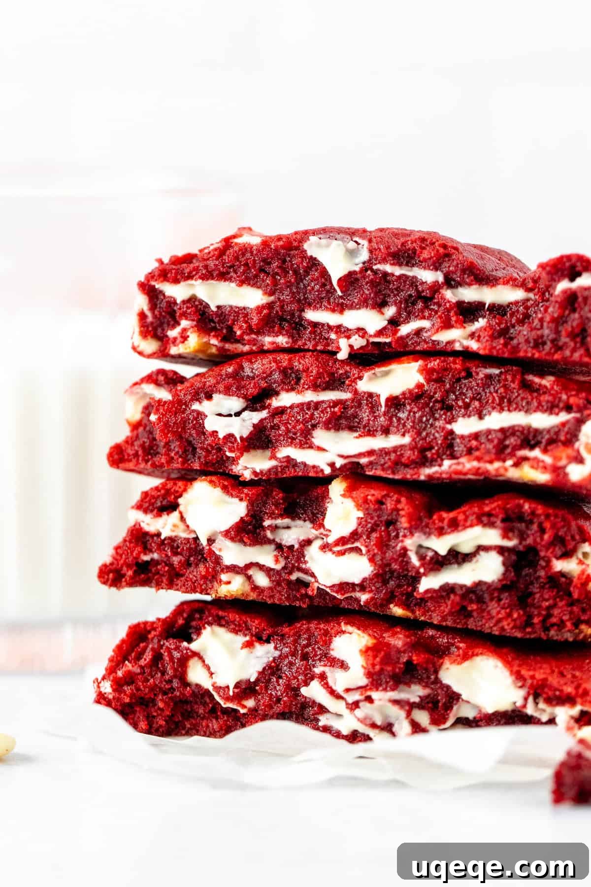 Plush Red Velvet Bakery Cookies 2 Stack of bakery-style red velvet cookies, broken in half, showing gooey center and chocolate chips