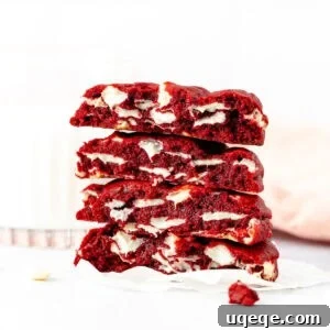 Bakery style red velvet cookies, broken in half and stacked on top of one another