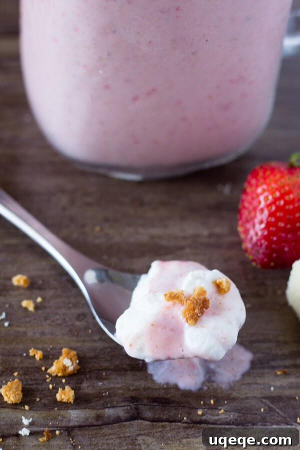Close-up of a Strawberry Shortcake Milkshake showing its thick texture and strawberry pieces.