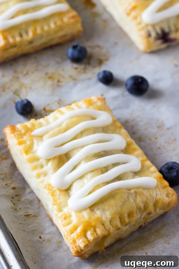 Flaky Homemade Blueberry Toaster Strudels 2 Buttery, flaky homemade blueberry toaster strudels with juicy blueberry centers and sweet vanilla glaze, ready to be enjoyed.