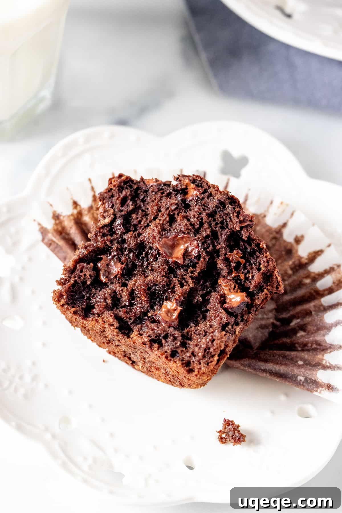 Ultimate Double Chocolate Banana Muffins 2 Half of a moist double chocolate banana muffin on a plate, revealing the soft interior and chocolate chips