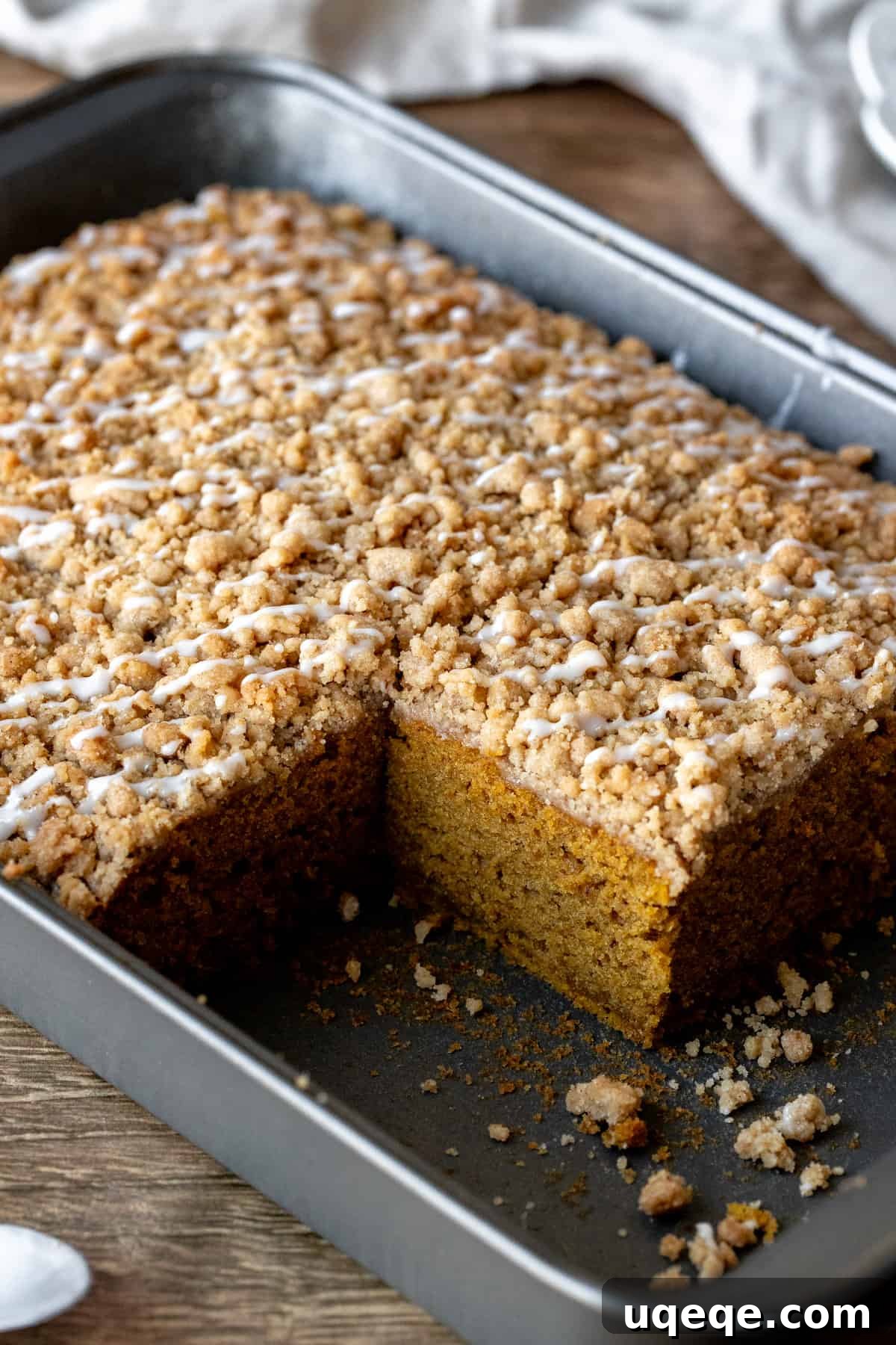 Spiced Pumpkin Crumble Coffee Cake 7 Pan of pumpkin coffee cake with streusel topping and drizzle of glaze