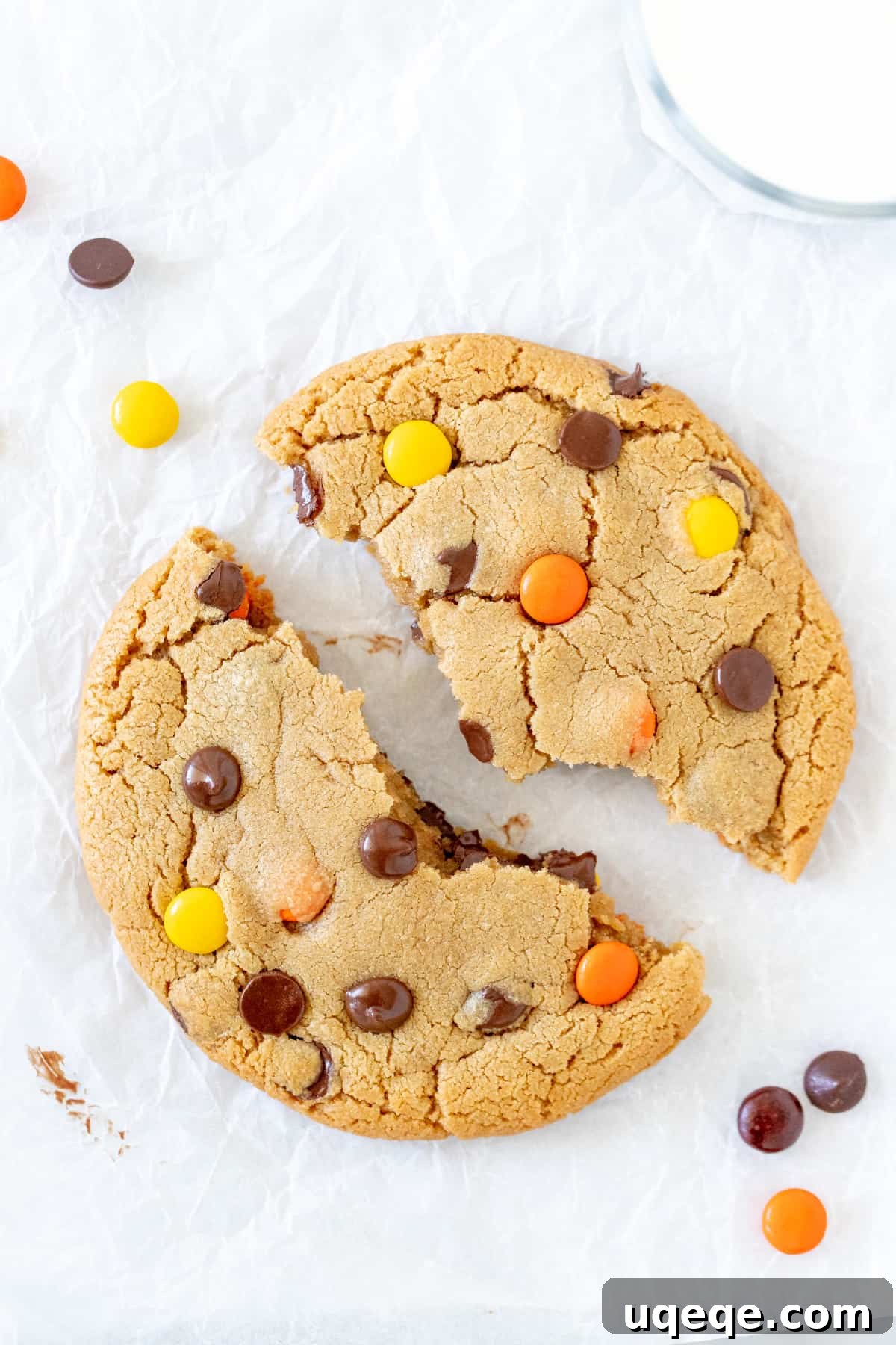 Easy Solo Peanut Butter Cookie 3 A large peanut butter cookie for one, freshly baked and broken in half, revealing a soft, gooey interior abundant with chocolate chips and colorful Reese's Pieces.