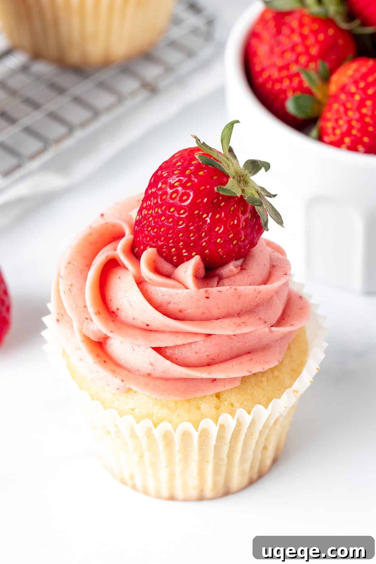 Strawberry Buttercream Delight: Crafted with Fresh or Frozen Berries 2 Vanilla cupcake with strawberry buttercream frosting, showcasing its creamy texture and vibrant color.
