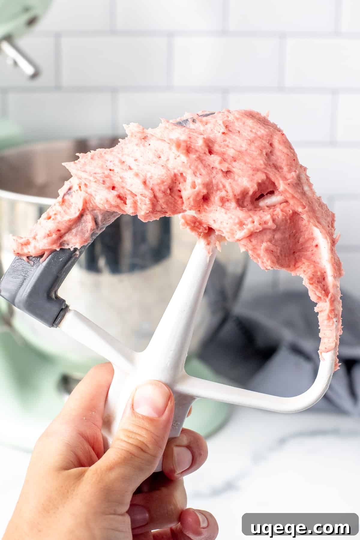 Strawberry Buttercream Delight: Crafted with Fresh or Frozen Berries 6 Electric mixer incorporating the reduced strawberry puree into the buttercream, showing the beautiful pink color developing.