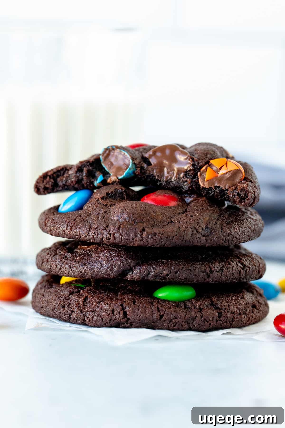 Rainbow Candy Chocolate Cookies 2 Stack of chocolate M&M cookies with top cookie broken in half, revealing gooey interior