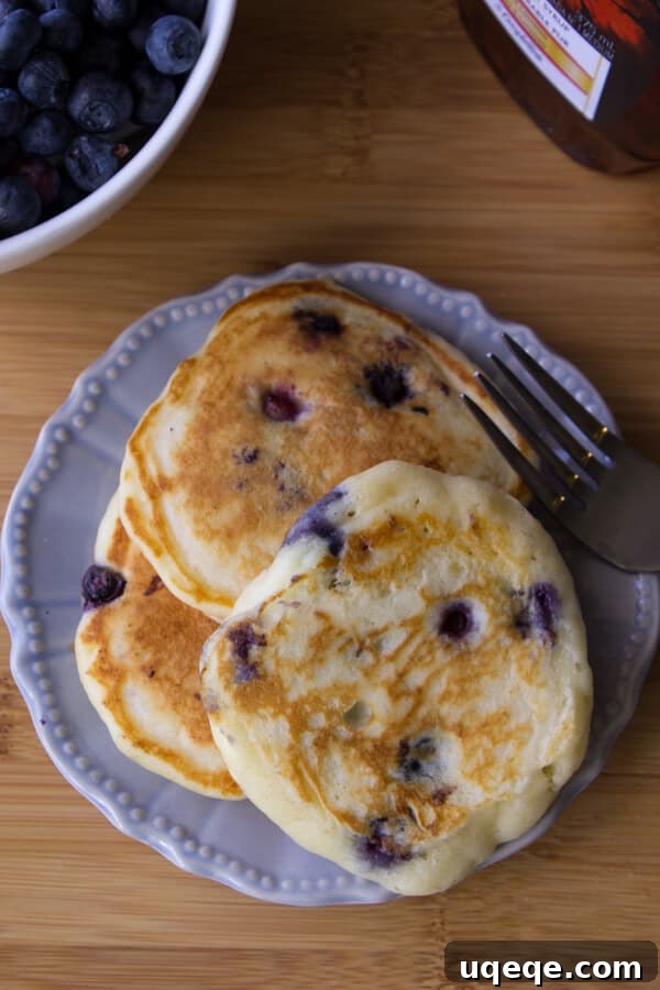 Fluffy Blueberry Buttermilk Stacks 4 A stack of golden Blueberry Buttermilk Pancakes with syrup, ready to be enjoyed. The ultimate guide to making the best fluffy pancakes at home.