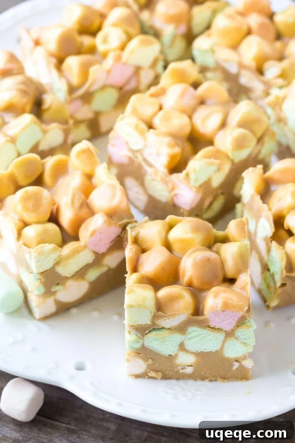 Speckled Peanut Butter Marshmallow Delights 4 A charming plate laden with perfectly formed Confetti Squares, showcasing their vibrant rainbow marshmallow bits and inviting texture, also known as Peanut Butter Marshmallow Squares.