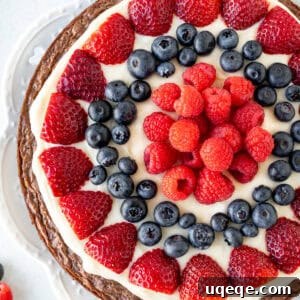 9-inch round brownie topped with cream cheese frosting and fresh berries