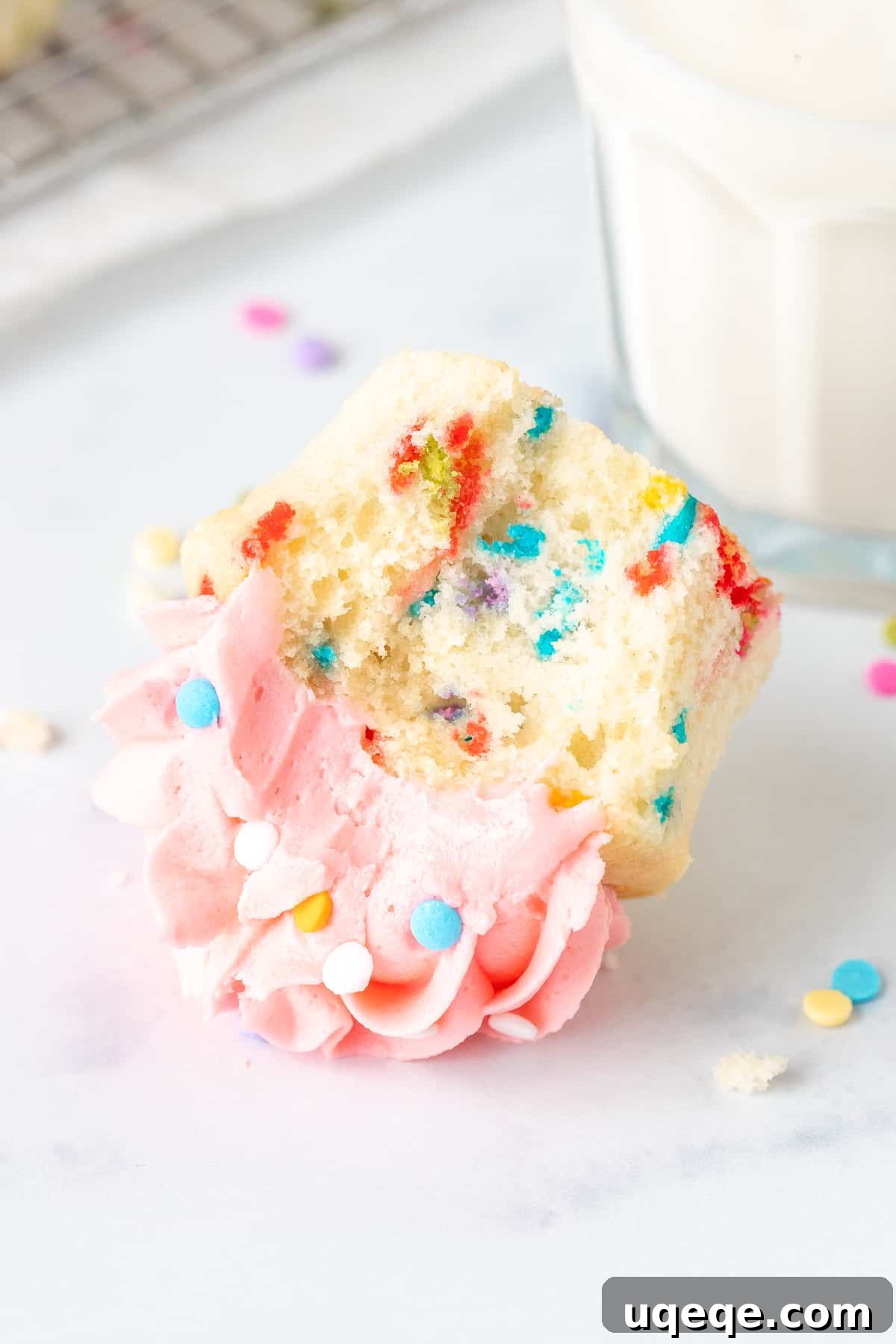 Funfetti cupcake with a bite taken out, on its side