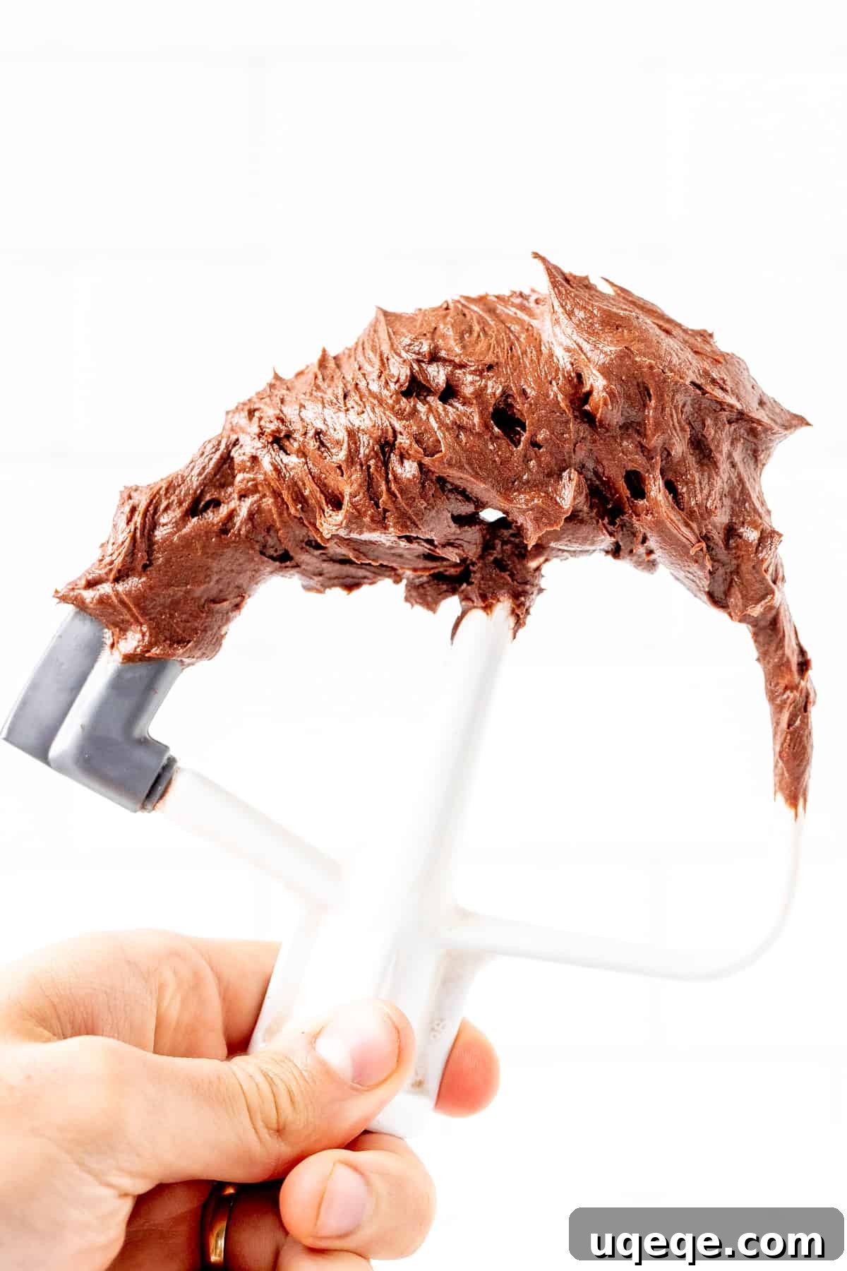 Kitchenaid beater covered in luxurious homemade chocolate frosting, showcasing its creamy texture.