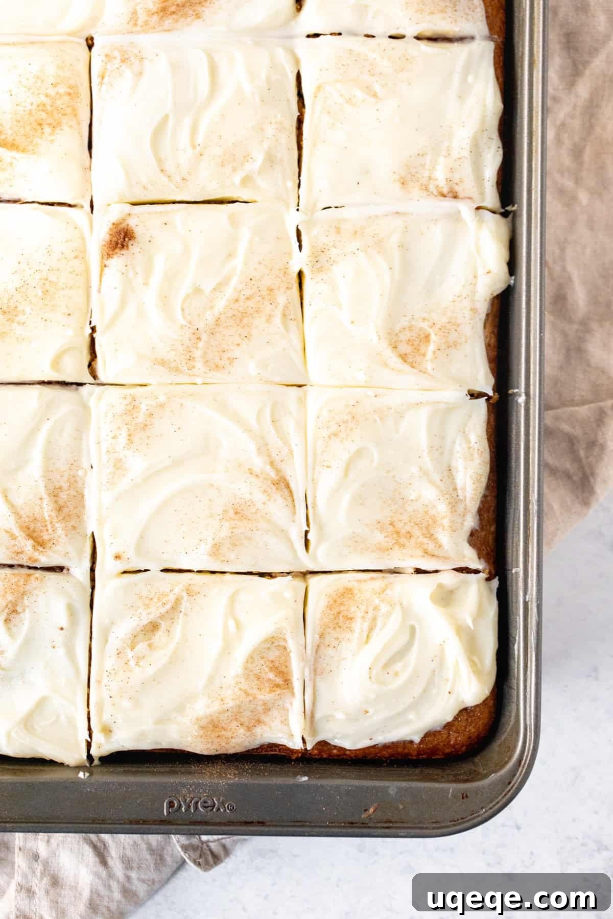 Orchard Spice Cake with Cream Cheese Cloud 10 A pan of frosted apple spice cake, already sliced into individual pieces, showcasing the deliciousness within.